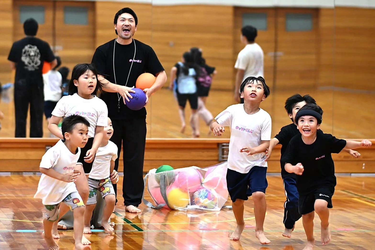 芦田塾の教室でボール遊びをする代表とこどもたち